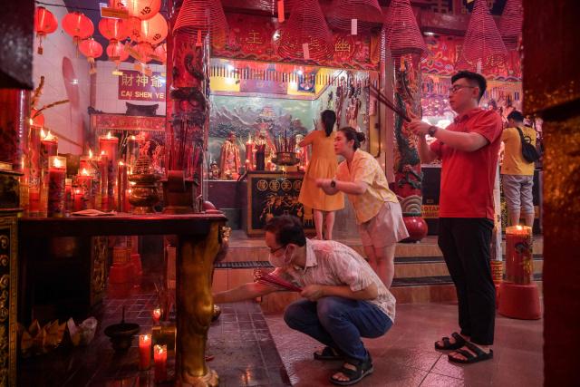 People offer prayers on the first day of the Lunar New Year of the Horse at Hong San Koo Tee temple in Surabaya on February 17, 2026. (Photo by JUNI KRISWANTO / AFP)