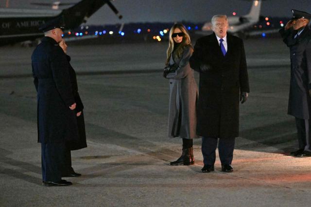 US President Donald Trump greets the press with First Lady Melania Trump by his side upon arrival at Joint Base Andrews in Maryland, on February 16, 2026. Trump is returning to Washington, DC after spending the holiday weekend at his Mar-a-Lago resort. (Photo by Mandel NGAN / AFP)