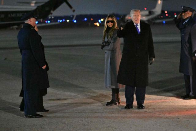 US President Donald Trump greets the press with First Lady Melania Trump by his side upon arrival at Joint Base Andrews in Maryland, on February 16, 2026. Trump is returning to Washington, DC after spending the holiday weekend at his Mar-a-Lago resort. (Photo by Mandel NGAN / AFP)