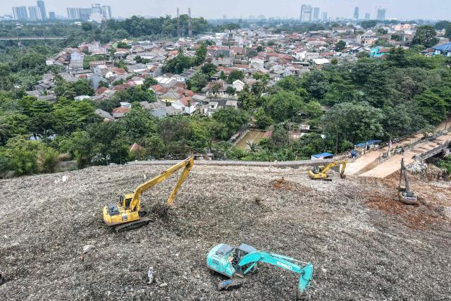 This aerial picture taken on January 20, 2026, shows excavators on a heap of trash at the Cipeucang landfill in South Tangerang, Banten, which often slides and clogs the river, sending waste to the outskirts of Jakarta during heavy rains. Garbage-choked streets, overloaded landfills and the fear of trash avalanches haunt greater Jakarta, as the world's most populous metropolis grapples with a waste crisis. (Photo by BAY ISMOYO / AFP) / To go with 'INDONESIA-ENVIRONMENT-WASTE-CRISIS,FOCUS' by Dessy SAGITA