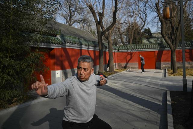 This picture taken on February 4, 2026 shows men exercising at Ritan Park in Beijing. Fifteen years ago, Beijing's Liangma riverbanks would have been smog-choked and deserted in winter, but these days they are dotted with families and exercising pensioners most mornings. The turnaround is the result of a years-long campaign that threw China's state power behind policies like moving factories and electrifying vehicles to improve some the world's worst air pollution. (Photo by Pedro PARDO / AFP) / To go with AFP story China-environment-air pollition-politics, FOCUS by Peter Catterall and Rebecca Bailey