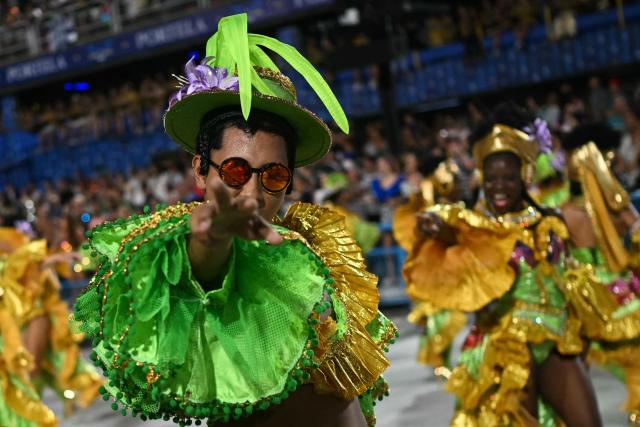 TOPSHOT - A reveller of the Mocidade Independente de Padre Miguel samba school performs during the second night of the Rio Carnival at the Marques de Sapucai Sambadrome in Rio de Janeiro, Brazil on February 16, 2026. (Photo by Mauro PIMENTEL / AFP)