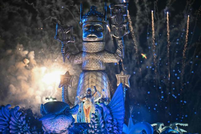 A reveller of the Beija-Flor de Nipolis samba school performs on a float during the second night of the Rio Carnival at the Marques de Sapucai Sambadrome in Rio de Janeiro, Brazil, early on February 17, 2026. (Photo by Mauro PIMENTEL / AFP)