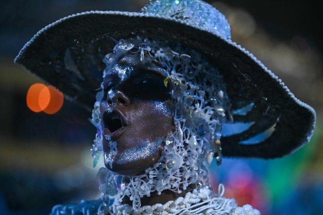A reveller of the Beija-Flor de Nipolis samba school performs during the second night of the Rio Carnival at the Marques de Sapucai Sambadrome in Rio de Janeiro, Brazil, early on February 17, 2026. (Photo by Mauro PIMENTEL / AFP)