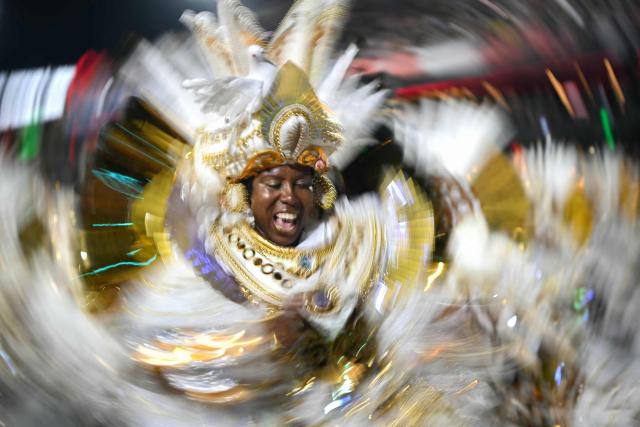 A reveller of the Beija-Flor de Nipolis samba school performs during the second night of the Rio Carnival at the Marques de Sapucai Sambadrome in Rio de Janeiro, Brazil, early on February 17, 2026. (Photo by Mauro PIMENTEL / AFP)