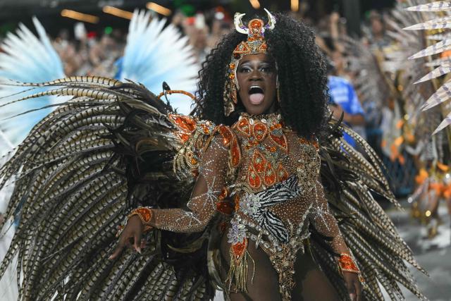 A reveller of the Beija-Flor de Nipolis samba school performs during the second night of the Rio Carnival at the Marques de Sapucai Sambadrome in Rio de Janeiro, Brazil, early on February 17, 2026. (Photo by Mauro PIMENTEL / AFP)