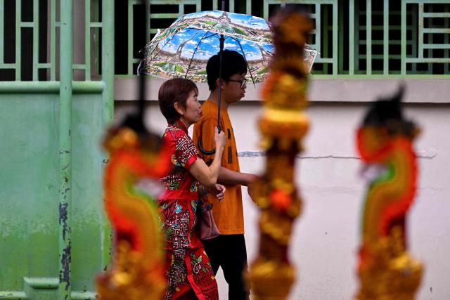 People walk to pray at a temple on the first day of the Lunar New Year of the Horse in Banda Aceh, Indonesia's Aceh province on February 17, 2026. (Photo by CHAIDEER MAHYUDDIN / AFP/Chaideer MAHYUDDIN / AFP)