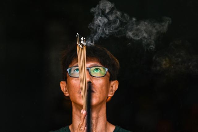 A man burns incense as he prays at a temple on the first day of the Lunar New Year of the Horse in Banda Aceh, Indonesia's Aceh province on February 17, 2026. (Photo by CHAIDEER MAHYUDDIN / AFP/Chaideer MAHYUDDIN / AFP)