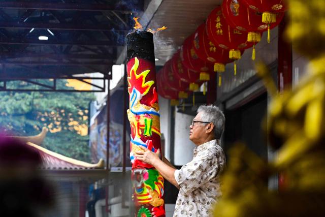 A man burns incense as he prays at a temple on the first day of the Lunar New Year of the Horse in Banda Aceh, Indonesia's Aceh province on February 17, 2026. (Photo by CHAIDEER MAHYUDDIN / AFP/Chaideer MAHYUDDIN / AFP)