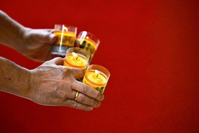 A man burns candles as he prays at a temple on the first day of the Lunar New Year of the Horse in Banda Aceh, Indonesia's Aceh province on February 17, 2026. (Photo by CHAIDEER MAHYUDDIN / AFP/Chaideer MAHYUDDIN / AFP)