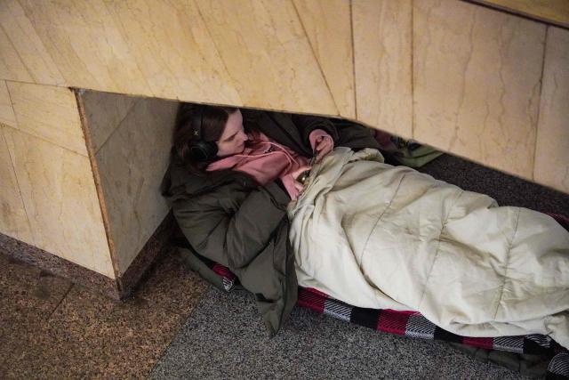 A girl looks at her phone as she takes shelter at a metro station during an air raid alert, in Kyiv, early on February 17, 2026, amid the Russian invasion of Ukraine. (Photo by Serhii Okunev / AFP)