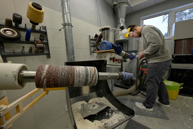 An employee works in the private prosthetics workshop in the Leningrad region on January 22, 2026. (Photo by Olga MALTSEVA / AFP)
