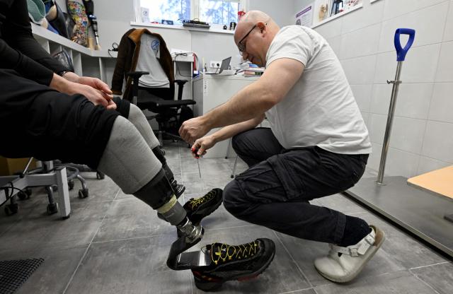 Mikhail Moskovtsev, 53, the private prosthetics workshop head, works on a patient's prosthetic limbs at the studio's grounds in the Leningrad region on January 22, 2026. (Photo by Olga MALTSEVA / AFP)