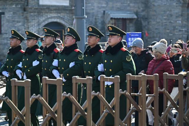 Chinese paramilitary police officers escort people to enter the Lama Temple on the first day of the Lunar New Year of the Horse in Beijing on February 17, 2026. (Photo by Adek BERRY / AFP)