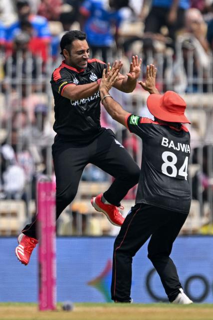 Canada's Saad Bin Zafar (L) celebrates with captain Dilpreet Bajwa after taking the wicket of New Zealand's Tim Seifert during the 2026 ICC Men's T20 Cricket World Cup group stage match between Canada and New Zealand at the MA Chidambaram Stadium in Chennai on February 17, 2026. (Photo by R. Satish BABU / AFP)