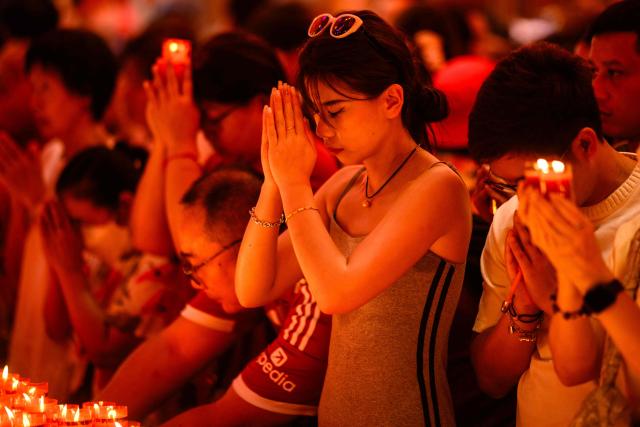 People pray in Wat Mangkon Kamalawat temple on the first day of the Lunar New Year of the Horse in the Chinatown area of Bangkok on February 17, 2026. (Photo by ANTHONY WALLACE / AFP)