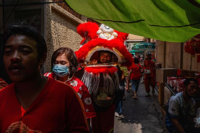 Performers walk down an alleyway on the first day of the Lunar New Year of the Horse in the Chinatown area of Bangkok on February 17, 2026. (Photo by ANTHONY WALLACE / AFP)