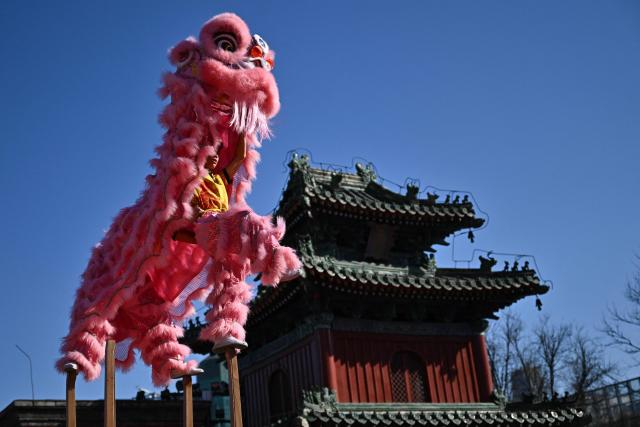 Lion dancers perform at Dongyue Temple on the first day of the Lunar New Year of the Horse in Beijing on February 17, 2026. (Photo by Pedro PARDO / AFP)