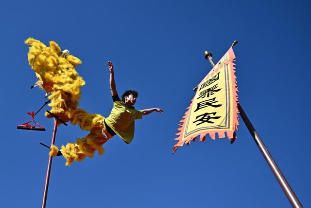 Lion dancers perform at Dongyue Temple on the first day of the Lunar New Year of the Horse in Beijing on February 17, 2026. (Photo by Pedro PARDO / AFP)