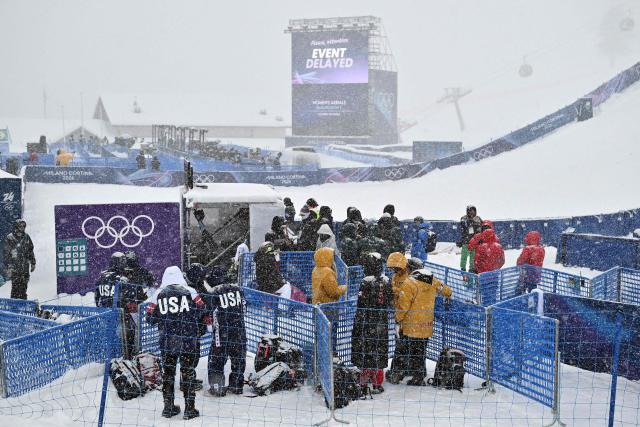 Team staff members stand by as the competition is delayed due to snowfall in the freestyle skiing women's aerials qualification 1 during the Milano Cortina 2026 Winter Olympic Games at Livigno Aerials & Moguls Park, in Livigno (Valtellina), on February 17, 2026. (Photo by Jeff PACHOUD / AFP)