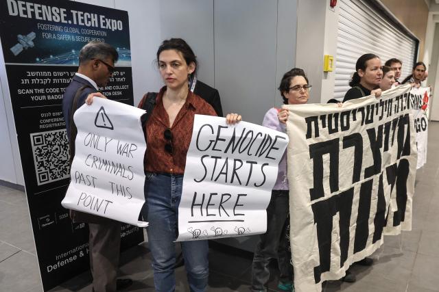 Israeli left-wing demonstrators hold banners and placards during a protest against the arms industry at an international arms and security fair in Tel Aviv on February 17, 2026. (Photo by JACK GUEZ / AFP)