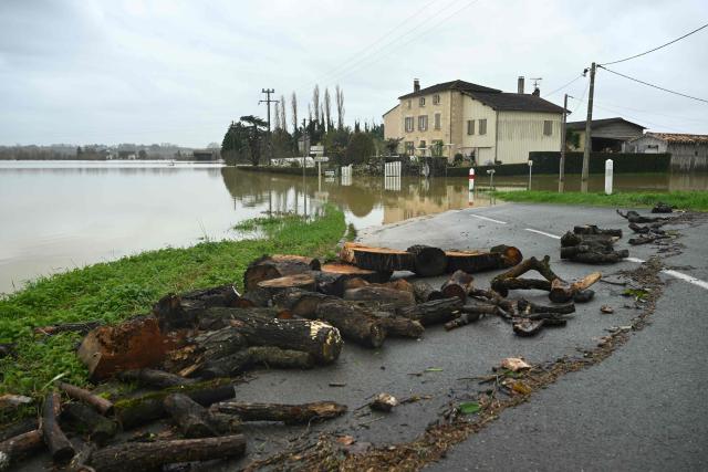 This photograph shows logs swept away by the flood next to a house flooded by the Garonne river in La Reole, southwestern France, on February 17, 2026. The flood alert system in France has been working at a record pace as relentless rain over the past month has saturated soils, the head of the agency told AFP on February 14, 2026. "For 30 days we have been in continuous orange or red alert somewhere on the national territory," Lucie Chadourne-Facon, director of Vigicrues, told AFP, referring to the two highest alert levels. (Photo by Gaizka IROZ / AFP)