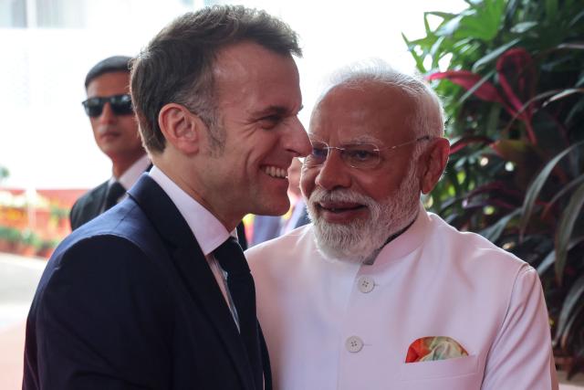 France's President Emmanuel Macron (L) is welcomed by India's Prime Minister Narendra Modi upon arrival for a bilateral meeting in Mumbai on February 17, 2026. (Photo by Ludovic MARIN / AFP)