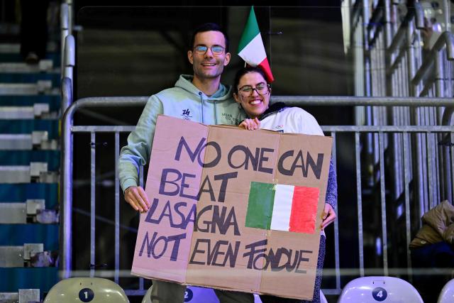 Supporters of Team Italy wave hold a placard in the stands ahead of the men's qualification play-off ice hockey match between Switzerland and Italy during the Milano Cortina 2026 Winter Olympic Games at the Milano Rho Ice Hockey Arena in Milan, on February 17, 2026. (Photo by Piero CRUCIATTI / AFP)
