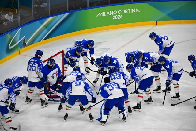 Italy's players gather in a huddle ahead of the men's qualification play-off ice hockey match between Switzerland and Italy during the Milano Cortina 2026 Winter Olympic Games at the Milano Rho Ice Hockey Arena in Milan, on February 17, 2026. (Photo by Piero CRUCIATTI / AFP)