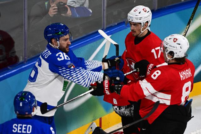 Italy's #36 Cristiano Digiacinto and Switzerland's #08 Simon Knak fight during the men's qualification play-off ice hockey match between Switzerland and Italy during the Milano Cortina 2026 Winter Olympic Games at the Milano Rho Ice Hockey Arena in Milan, on February 17, 2026. (Photo by Piero CRUCIATTI / AFP)