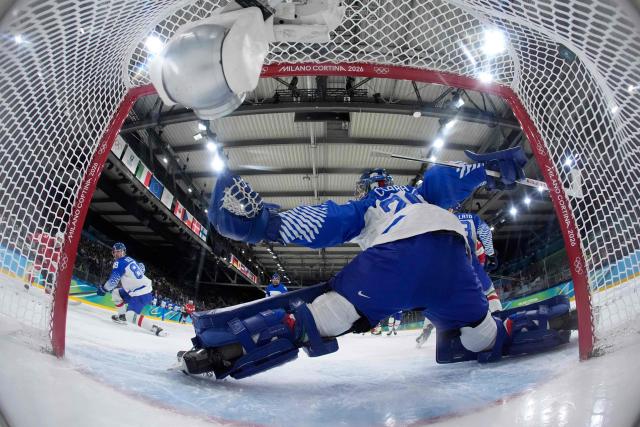 Switzerland's #23 Philipp Kurashev (L) scores his team's first goal past Italy's #20 Damian Clara during the men's qualification play-off ice hockey match between Switzerland and Italy during the Milano Cortina 2026 Winter Olympic Games at the Milano Rho Ice Hockey Arena in Milan, on February 17, 2026. (Photo by Darko Bandic / POOL / AFP)