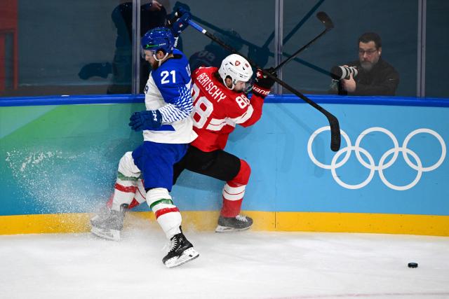 Italy's #21 Daniel Glira fights for the puck with with Switzerland's #88 Christoph Bertschy during the men's qualification play-off ice hockey match between Switzerland and Italy during the Milano Cortina 2026 Winter Olympic Games at the Milano Rho Ice Hockey Arena in Milan, on February 17, 2026. (Photo by Piero CRUCIATTI / AFP)