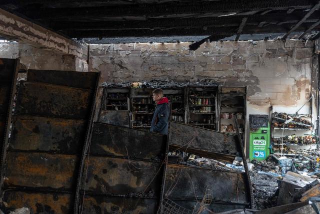 A resident walks through a damaged grocery store building at the site of a Russian attack in Odesa on February 17, 2026, amid the Russian invasion of Ukraine. Ukrainian officials in the port city of Odesa reported on February 17, 2026, damage to buildings and at least two wounded after a drone attack overnight. (Photo by Oleksandr GIMANOV / AFP)