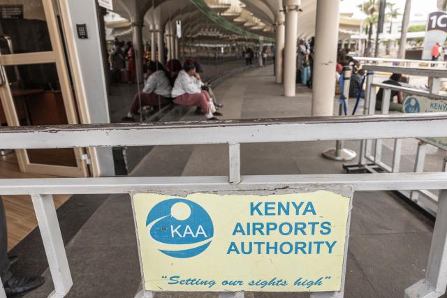 Passengers wait in front of a closed door at the departures of the Jomo Kenyatta International Airport (JKIA) in Nairobi on February 17, 2026 amid a strike by the Kenyan Aviation Workers Union (KAWU). Passengers were stranded at the Jommo Kenyatta International Aiport (JKIA) on Tuesday as a strike by air traffic controllers entered a second day, leaving many travellers waiting for hours. A worker's strike disrupted flights and air traffic control operations at Kenya's main airport on Monday, the national carrier said.
Kenya Airways (KQ) warned passengers of "possible schedule adjustments, including delays" and advised them not to proceed to the airport without first confirming their flight status. (Photo by SIMON MAINA / AFP)