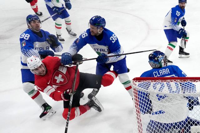 Switzerland's #09 Damien Riat fights for the puck with Italy's #36 Cristiano Digiacinto during the men's qualification play-off ice hockey match between Switzerland and Italy during the Milano Cortina 2026 Winter Olympic Games at the Milano Rho Ice Hockey Arena in Milan, on February 17, 2026. (Photo by Darko Bandic / POOL / AFP)