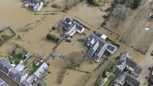 This aerial photograph taken on February 17, 2026, shows residential buildings submerged by the overflowing Loire River in Denee, western France. The swelling of the Loire River caused a "major flood" on February 17, 2026 near Angers as three departments — Maine-et-Loire, Gironde and Lot-et-Garonne — remain under red alert, the highest warning level. (Photo by Damien MEYER / AFP)