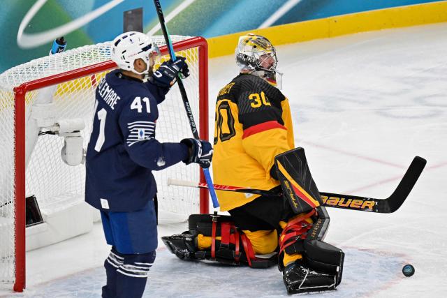 France's #41 Pierre-Edouard Bellemare (L) celebrates scoring his team's first goal against Germany's #30 Philipp Grubauer during the men's qualification play-off ice hockey match between Germany and France at the Milano Santagiulia Ice Hockey Arena during the Milano Cortina 2026 Winter Olympic Games in Milan, on February 17, 2026. (Photo by Alexander NEMENOV / AFP)