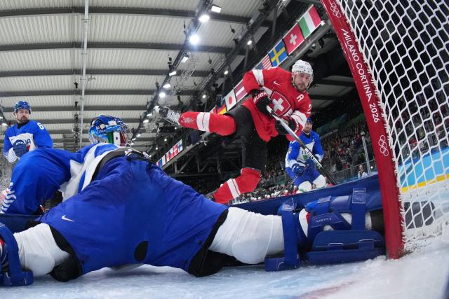 Switzerland's #22 Nino Niederreiter shoots but fails to score past Italy's #20 Damian Clara during the men's qualification play-off ice hockey match between Switzerland and Italy during the Milano Cortina 2026 Winter Olympic Games at the Milano Rho Ice Hockey Arena in Milan, on February 17, 2026. (Photo by Tao Xiyi / POOL / AFP)