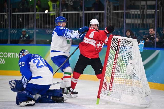 Italy's #37 Phil Pietroniro pushes Switzerland's #88 Christoph Bertschy into the goal posts during the men's qualification play-off ice hockey match between Switzerland and Italy during the Milano Cortina 2026 Winter Olympic Games at the Milano Rho Ice Hockey Arena in Milan, on February 17, 2026. (Photo by Piero CRUCIATTI / AFP)