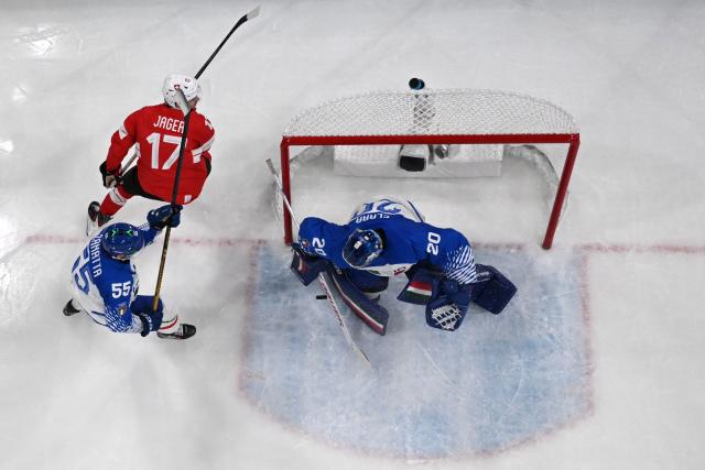 Italy's #20 Damian Clara makes a save from a shot played by Switzerland's #17 Ken Jager during the men's qualification play-off ice hockey match between Switzerland and Italy during the Milano Cortina 2026 Winter Olympic Games at the Milano Rho Ice Hockey Arena in Milan, on February 17, 2026. (Photo by Piero CRUCIATTI / AFP)
