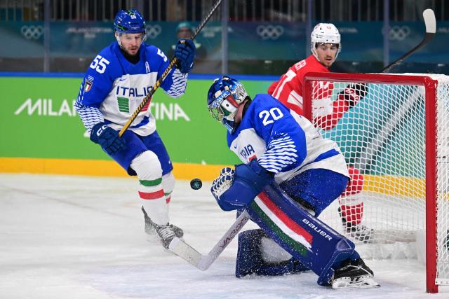 Italy's #20 Damian Clara makes a save from a shot played by Switzerland's #17 Ken Jager during the men's qualification play-off ice hockey match between Switzerland and Italy during the Milano Cortina 2026 Winter Olympic Games at the Milano Rho Ice Hockey Arena in Milan, on February 17, 2026. (Photo by Piero CRUCIATTI / AFP)