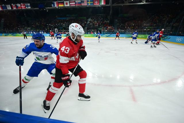 Italy's #36 Cristiano Digiacinto fights for the puck with Switzerland's #43 Andrea Glauser during the men's qualification play-off ice hockey match between Switzerland and Italy during the Milano Cortina 2026 Winter Olympic Games at the Milano Rho Ice Hockey Arena in Milan, on February 17, 2026. (Photo by PIERO CRUCIATTI / AFP)