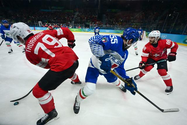 Italy's #55 Luca Zanatta fights for the puck with Switzerland's #79 Calvin Thurkauf and Switzerland's #88 Christoph Bertschy during the men's qualification play-off ice hockey match between Switzerland and Italy during the Milano Cortina 2026 Winter Olympic Games at the Milano Rho Ice Hockey Arena in Milan, on February 17, 2026. (Photo by PIERO CRUCIATTI / AFP)
