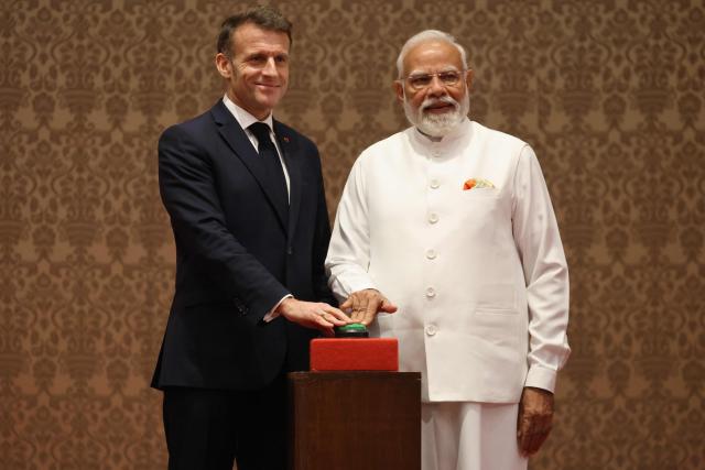 France's President Emmanuel Macron (L) and India's Prime Minister Narendra Modi (R) press a button to virtually inaugurate the assembly line of Airbus H-125 helicopters, at a press event in Mumbai on February 17, 2026. (Photo by Ludovic MARIN / AFP)