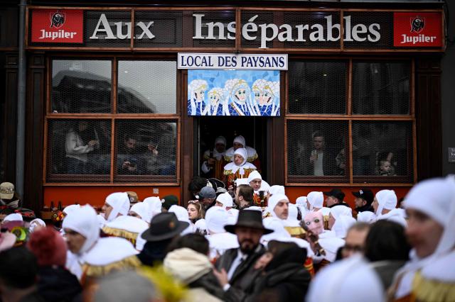 TOPSHOT - Carnival goers dressed up as Gilles de Binche, the oldest and principal participants in the Carnival of Binche, parade in Binche on February 17, 2026. The Binche Carnival tradition is one of the most ancient and representative of Wallonia and inscribed in 2008 on the Representative List of the Intangible Cultural Heritage of Humanity by UNESCO. (Photo by JOHN THYS / AFP)