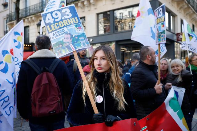 A protester holds a placard as Ile-de-France teachers called by an inter-union coalition demonstrate against the 2026 budget and planned teaching post cuts in Paris on February 17, 2026. (Photo by Charlotte SIEMON / AFP)