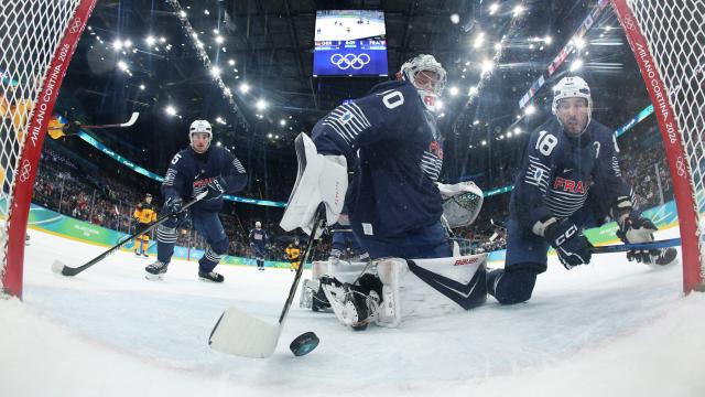 France's #30 Antoine Keller (C) saves the puck during the men's qualification play-off ice hockey match between Germany and France at the Milano Santagiulia Ice Hockey Arena during the Milano Cortina 2026 Winter Olympic Games in Milan, on February 17, 2026. (Photo by POOL / AFP)