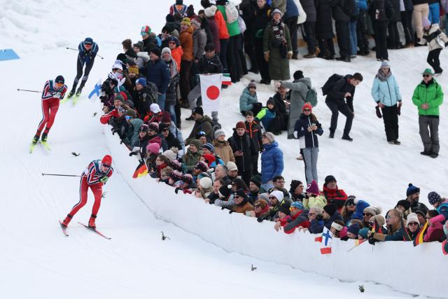 Norway's Andreas Skoglund (L) competes in the cross-country event of the nordic combined individual Gundersen large hill/10km at Tesero Cross Country Stadium at Lago di Tesero (Val di Fiemme) during the Milano Cortina 2026 Winter Olympic Games on February 17, 2026. (Photo by Anne-Christine POUJOULAT / AFP)
