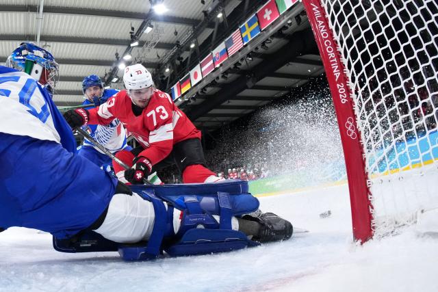 Italy's #20 Damian Clara makes a save from a shot played by Switzerland's #73 Sandro Schmid during the men's qualification play-off ice hockey match between Switzerland and Italy during the Milano Cortina 2026 Winter Olympic Games at the Milano Rho Ice Hockey Arena in Milan, on February 17, 2026. (Photo by Tao Xiyi / POOL / AFP)