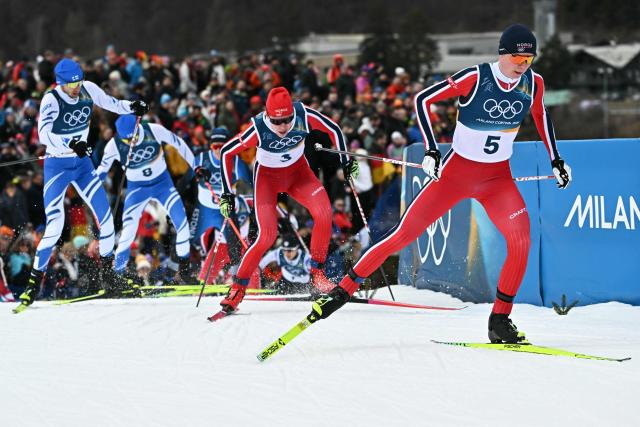Norway's Jens Luraas Oftebro (R) and Norway's Andreas Skoglund (C) compete in the cross-country event of the nordic combined individual Gundersen large hill/10km at Tesero Cross Country Stadium at Lago di Tesero (Val di Fiemme) during the Milano Cortina 2026 Winter Olympic Games on February 17, 2026. (Photo by Javier SORIANO / AFP)